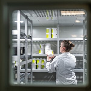 Person steht in einem Kühlraum und hält eine Dose in der Hand