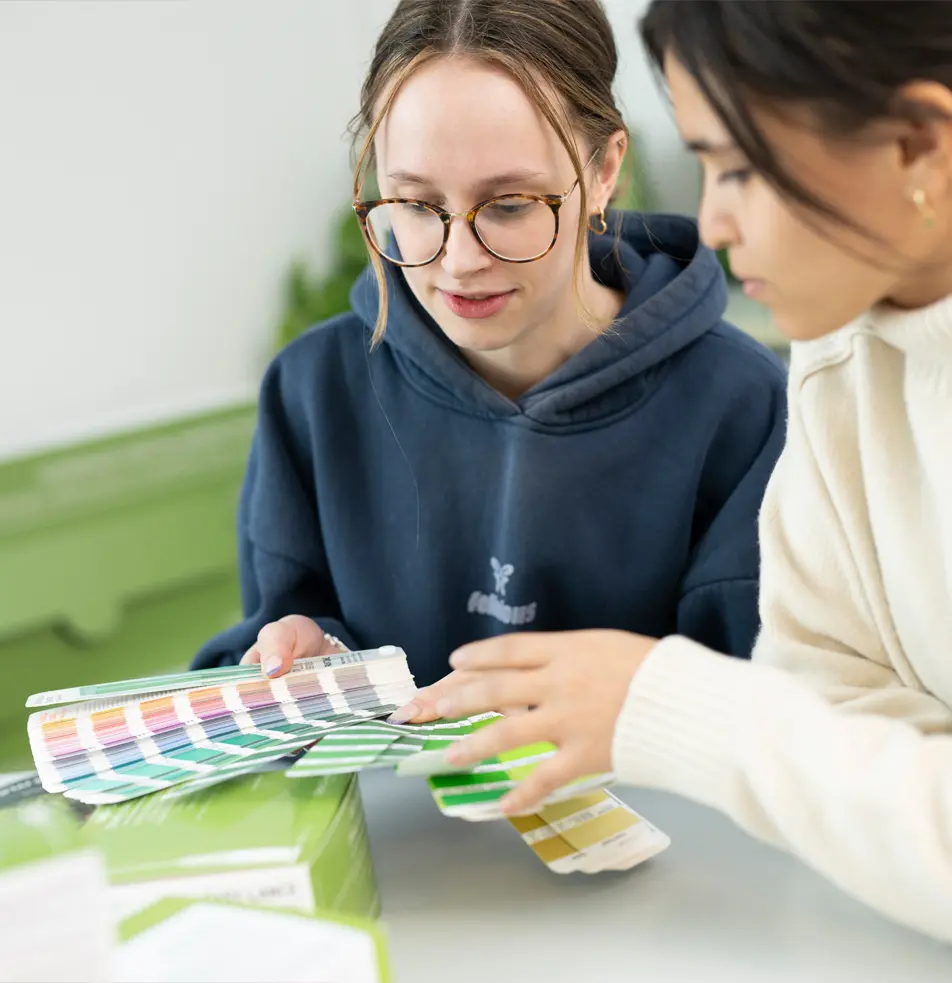 zwei Frauen schauen auf einen Farbfächer