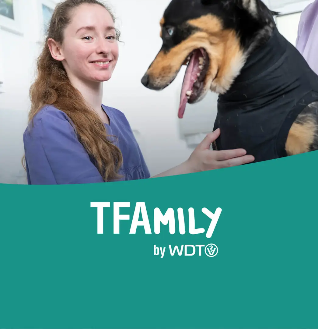 TFA lächelt und hält einen hund