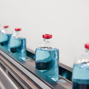 Flaschen mit Arzneimitteln fahren durch eine Produktionslinie
