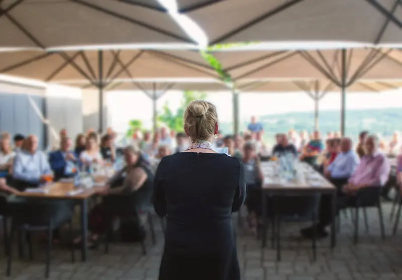 Person hält Rede vor der versammelten Genossenschaft