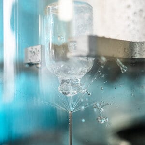 Eine kleine Flasche wird mit Wasser gespühlt